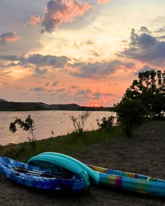 Kayaks by the river at sunset