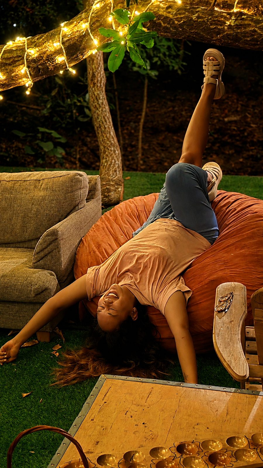 A guest collapsed in laughter on a beanbag under the garden lights