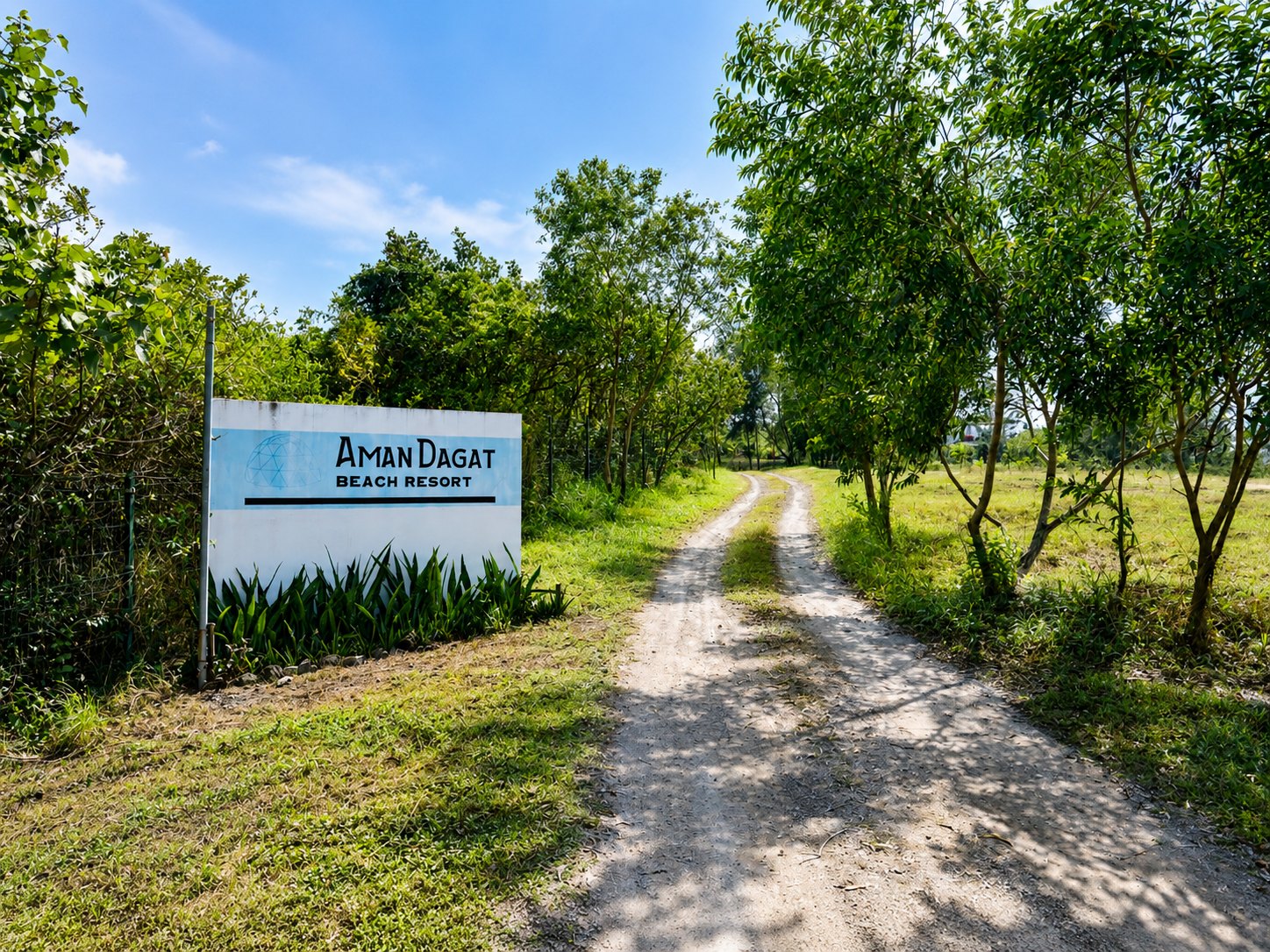 The AmanDagat Beach Resort entrance sign on the tree-lined lane