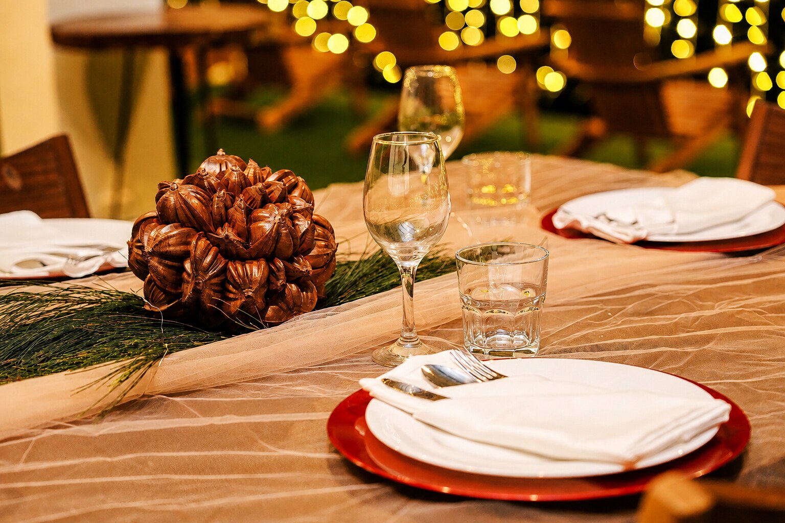 Table set with plates, glassware and warm lights for an evening meal