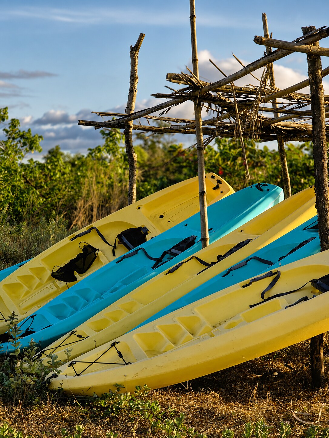 Yellow and blue kayaks stacked outdoors at AmanDagat