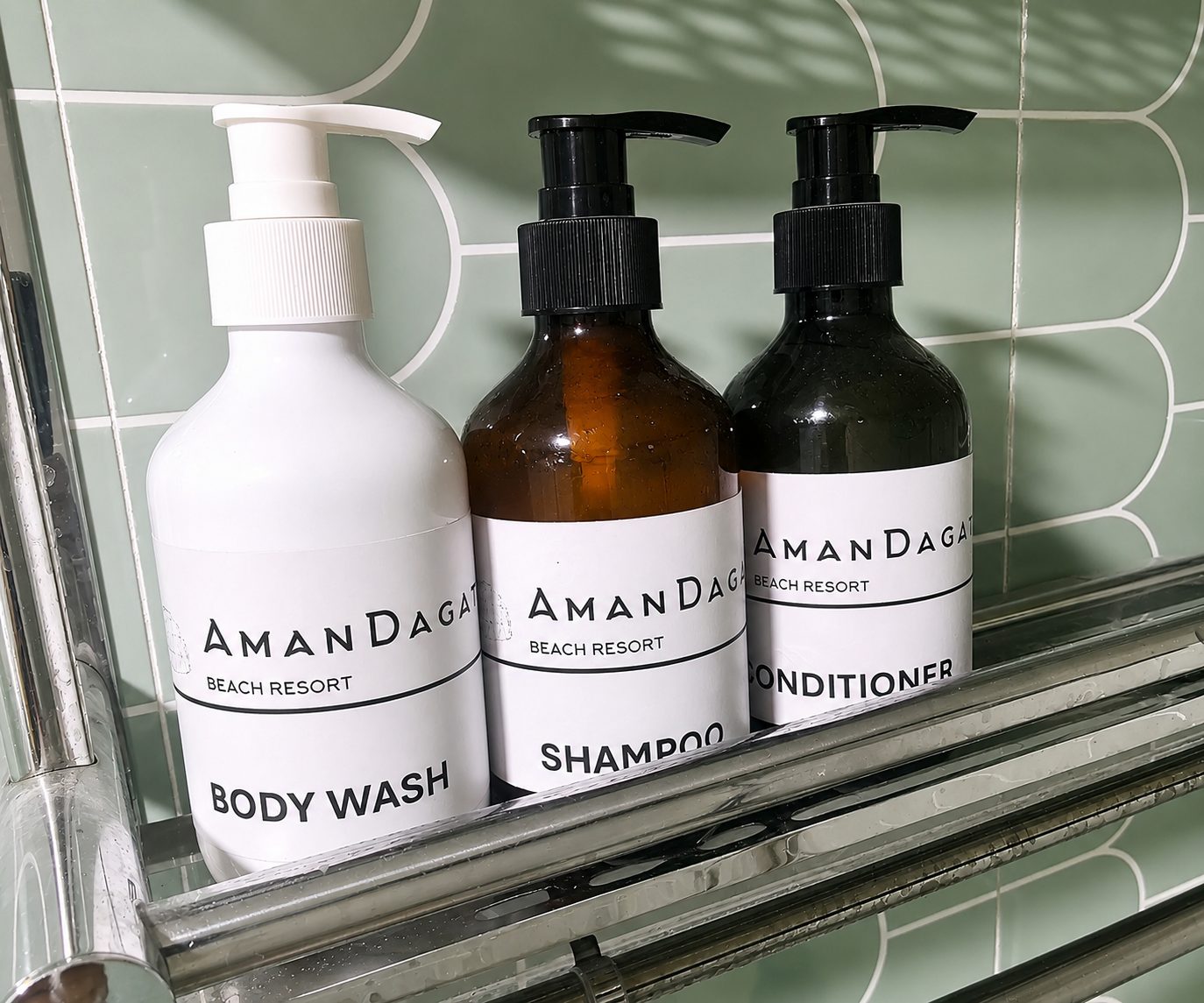 AmanDagat branded body wash, shampoo and conditioner on the shower shelf
