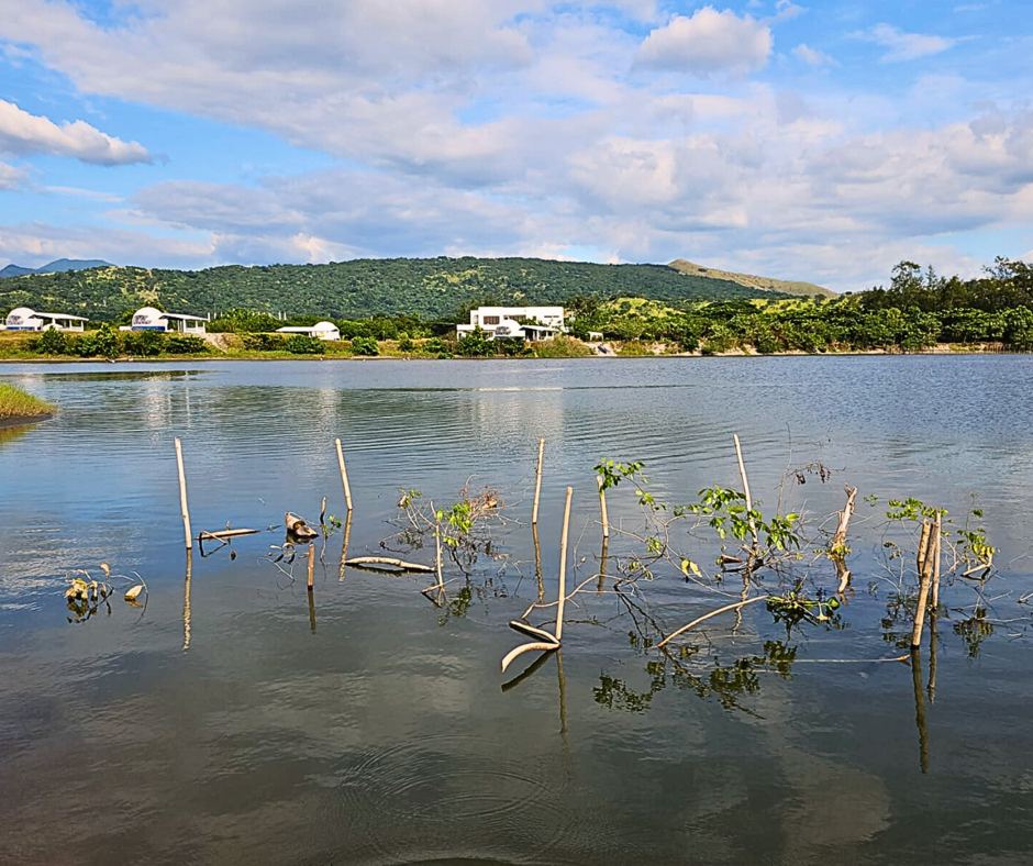 Calm water on Sindol Lagoon with AmanDagat Beach Resort on the far shore &mdash; San Felipe, Zambales