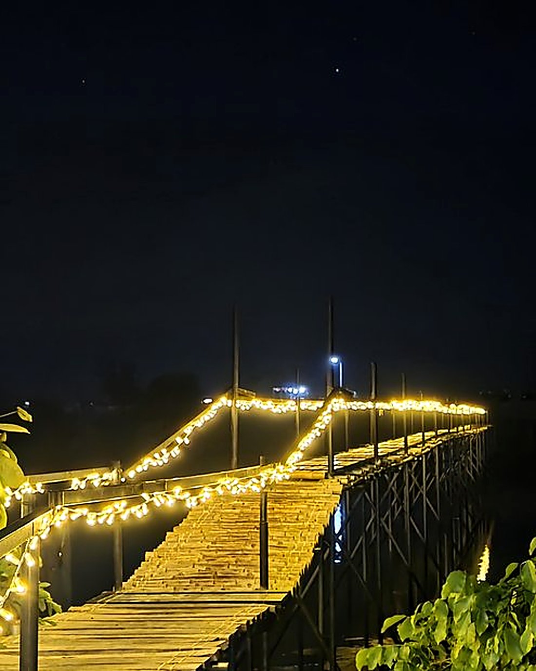 The Pearl Bridge lit at night over the river at AmanDagat Beach Resort