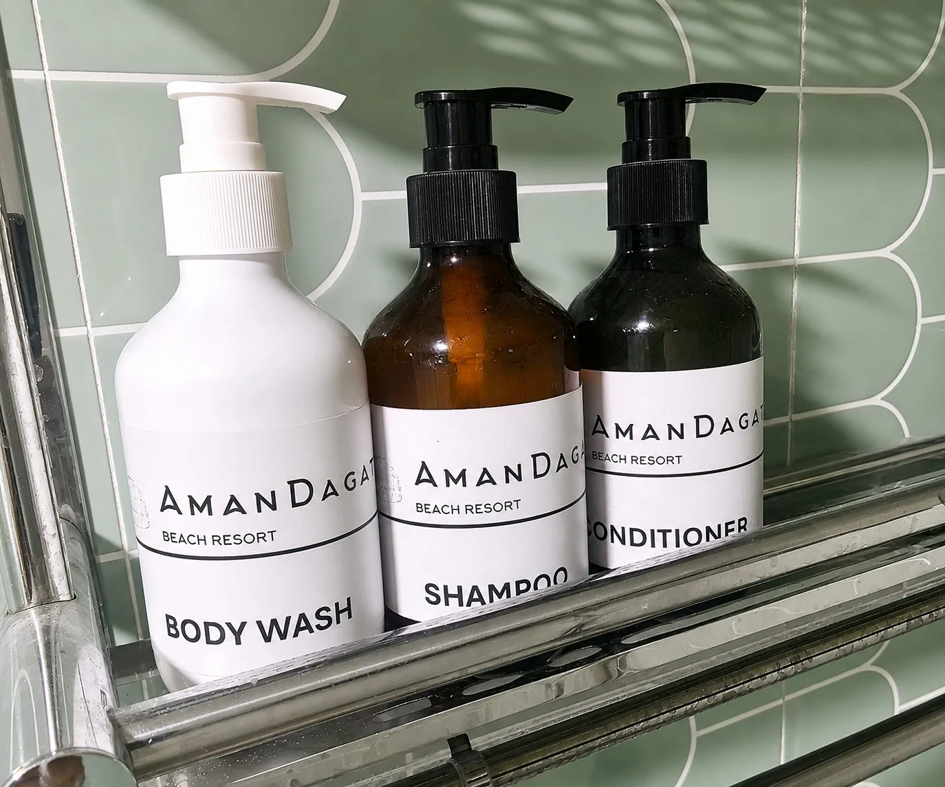 AmanDagat branded body wash, shampoo and conditioner on the shower shelf