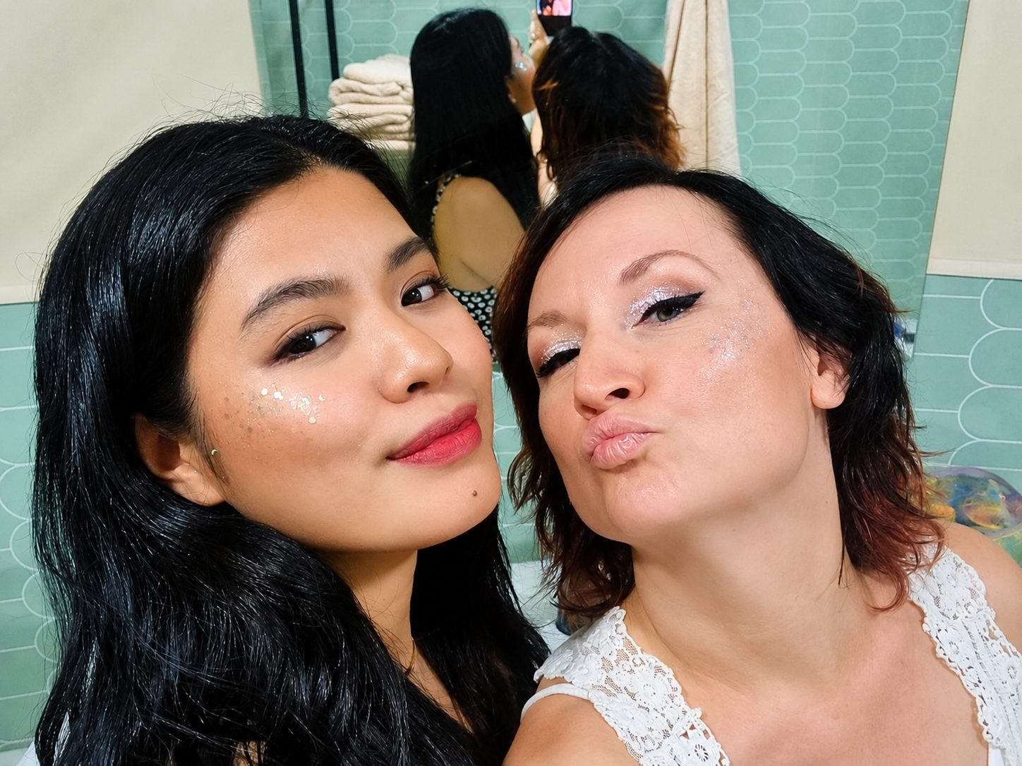 Two friends with glitter make-up getting ready