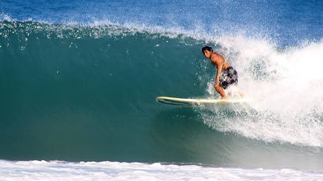 Surfer riding a breaking wave in San Felipe, Zambales